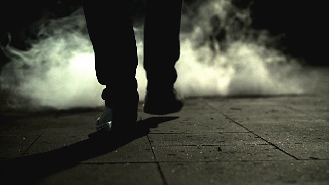 一个男人的腿在烟云附近行走。慢动作视频素材