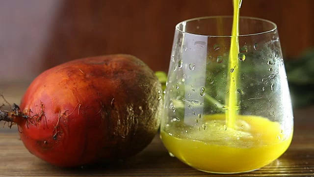 桌上玻璃杯里的黄色甜菜汁视频素材