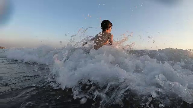 快乐的男孩在海里游泳溅起水花视频下载