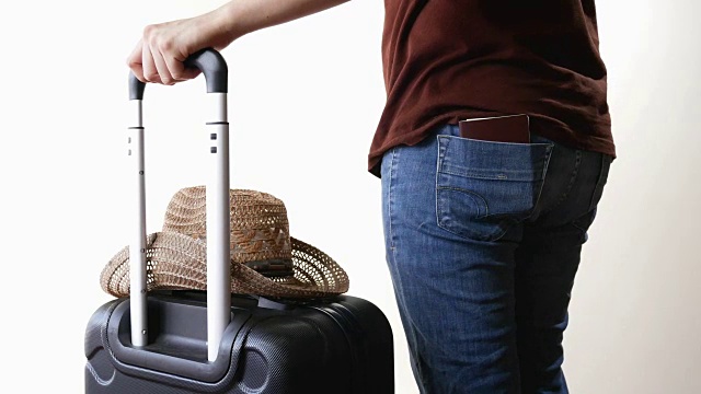 一名带着旅行行李和帽子的男子将护照放入牛仔裤后袋，准备出行视频下载