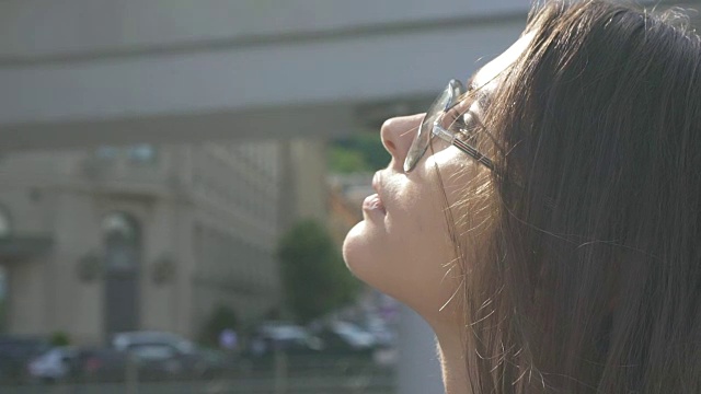 迷人的女人戴着太阳镜在大城市享受夏日，在户外放松视频素材