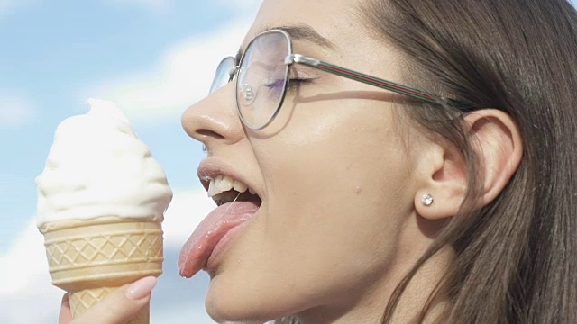 快乐的女性在炎热的夏天吃着冰淇淋，微笑着，甜甜的甜点视频下载