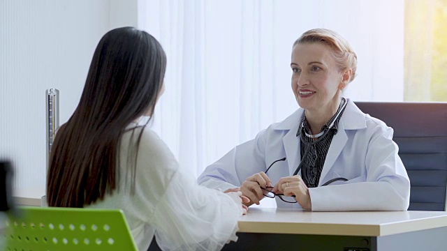 高级女医生在病房里与病人讨论或解释某事。视频素材