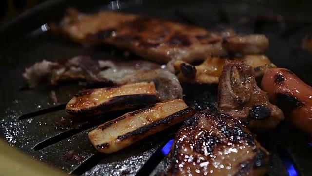 韩国烧烤架。人们在餐馆里用韩式烧烤做菜吃。4 k,特写。视频下载
