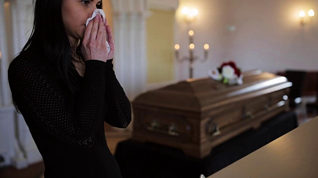 在教堂举行的葬礼上拿着抹布和棺材的女人视频下载