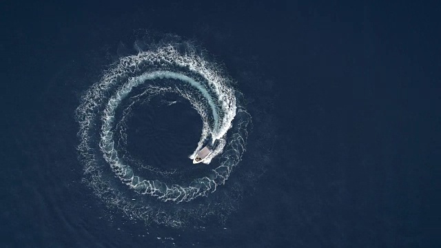 鸟瞰图的一艘船在希腊周围形成波浪在旋转。视频素材