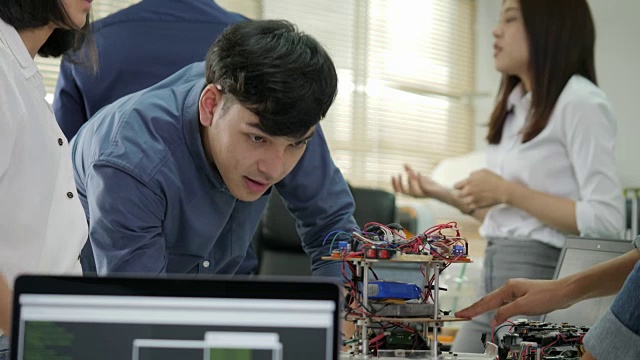 电子工程师团队一起工作，在一个项目上合作建造机器人。有技术或创新观念的人。视频素材