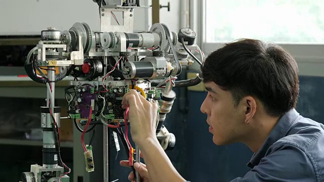 亚洲年轻电子工程师在实验室建造和修理机器人。有技术或创新观念的人。视频素材