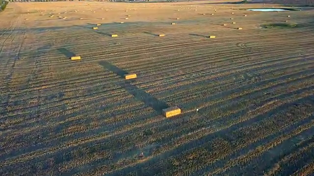日落时田野上的方形稻草捆的天线视频素材