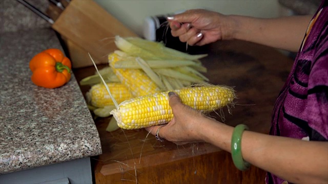慢动作的亚洲老妇人清洁和准备在她的厨房煮玉米视频下载