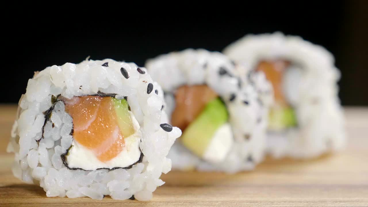 微距拍摄的寿司，生鱼片，浦卷和夜寿司。典型的日本菜，由米饭、鲑鱼或金枪鱼、虾和浸泡在酱油里的鱼卵组成。视频下载