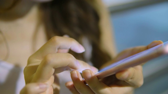 年轻的亚洲女性在晚上使用智能手机视频素材