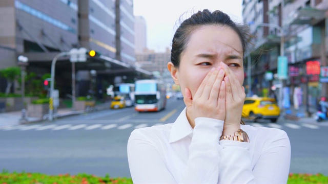 女商人在城市的室外咳嗽和打喷嚏视频素材