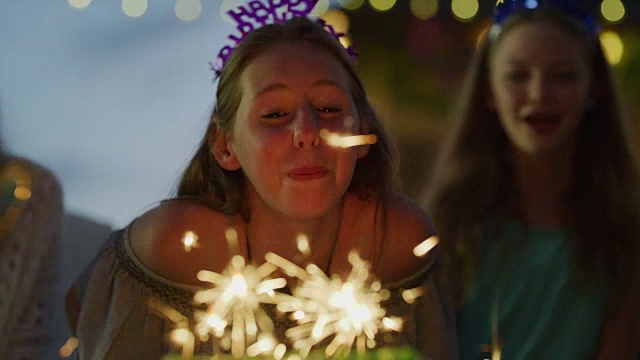 笑着的女孩成功地熄灭了生日蛋糕上的烟火/美国犹他州雪松山视频素材