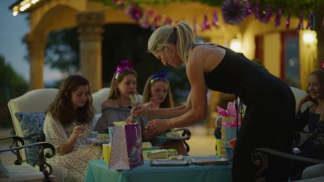 在美国犹他州雪松山的生日聚会上，一名妇女正在为女孩们切蛋糕视频素材
