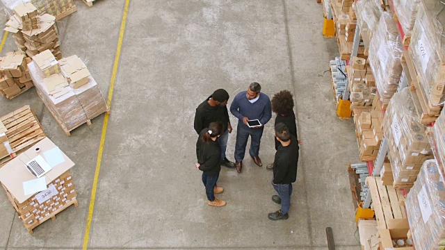 男经理在仓库与工人讨论视频素材