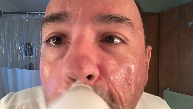 男人用浴室镜子里的洗面奶洗脸视频素材