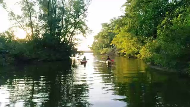 两艘独木舟和人们在风景优美的河上视频素材