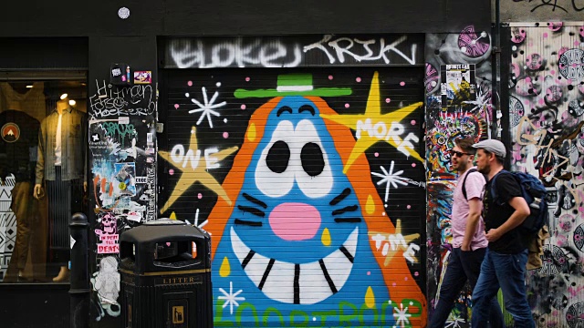 伦敦布里克巷，人们从色彩鲜艳的街头艺术前经过的慢镜头视频素材