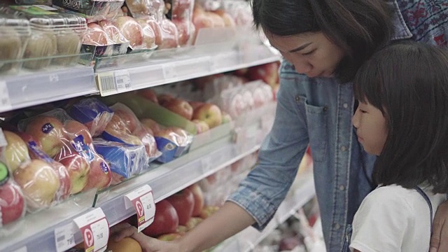 母女俩在超市选择水果和购物。4k视频素材