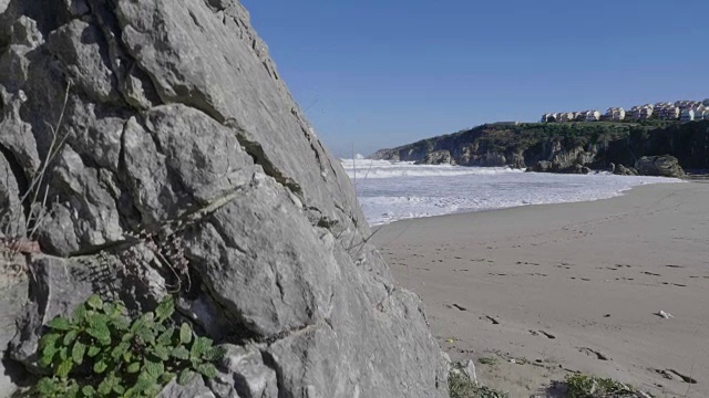 海浪和岩石在可爱的沙滩上视频素材