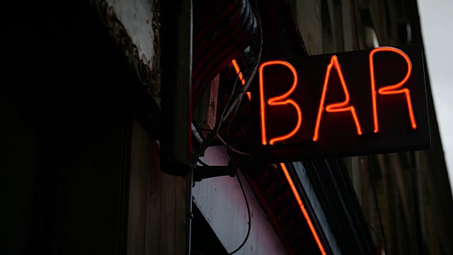 选择焦点拍摄的红色霓虹灯酒吧标志在黄昏视频下载