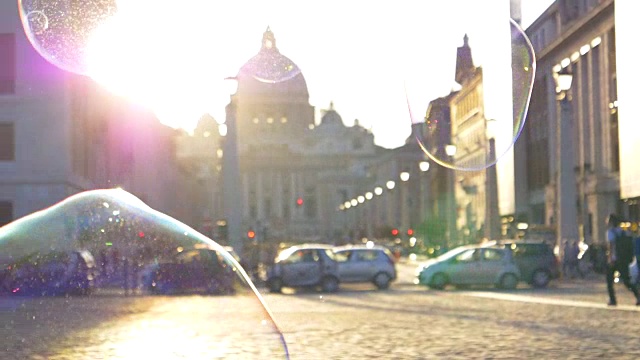 镜头光晕:五彩缤纷的肥皂泡在梵蒂冈广场的阳光下飞舞。视频下载