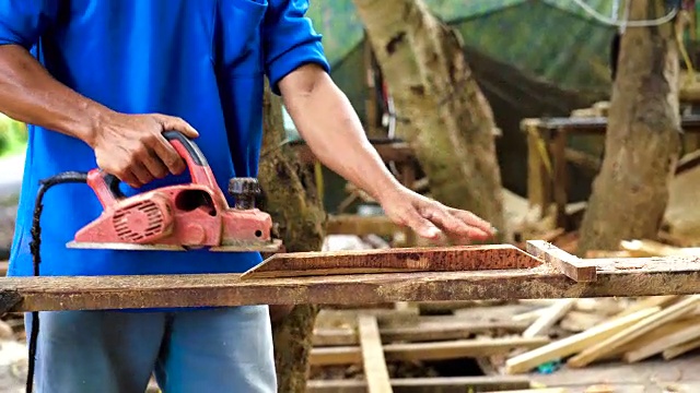 4k镜头亚洲工人在越南董塔丁Yen计划机器刨木头的场景，木工工具和机器概念视频下载