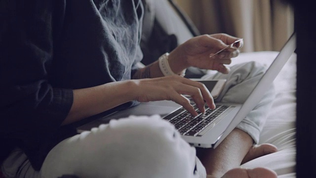 一个年轻女子在酒店房间里用笔记本电脑工作视频素材
