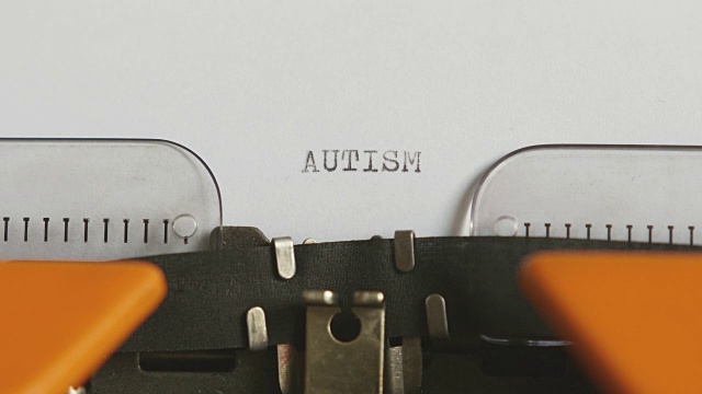 一个人用声音在一台旧打字机上写自闭症的特写镜头……视频素材