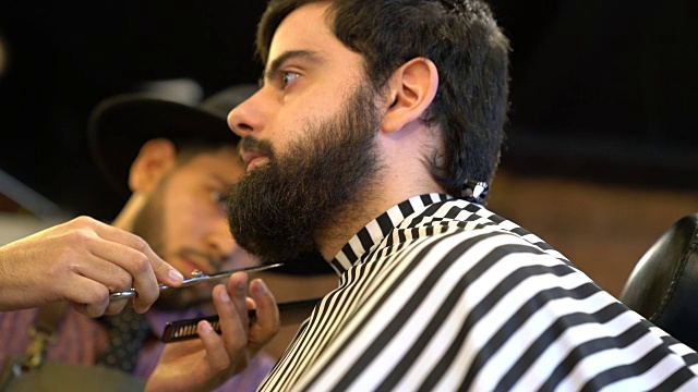 理发师用剪刀修剪顾客的胡须视频素材