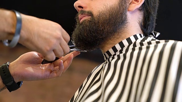 理发师在美发沙龙为顾客修剪胡须视频素材