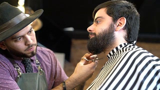 理发师用剪刀修剪男人的胡子视频素材