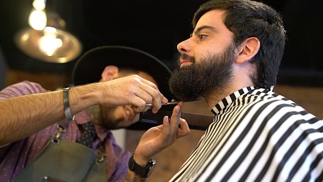 理发师在美发沙龙为男顾客修剪胡须视频素材