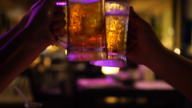 慢镜头FHD镜头特写敬酒和碰杯啤酒，在酒吧和餐厅一起欢呼，放松和饮料的概念视频下载
