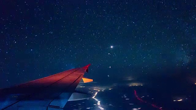 4K T/L夜间飞行星从飞机窗口观看视频素材
