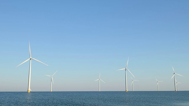 风力涡轮机与转动叶片在风在一个离岸风公园视频素材