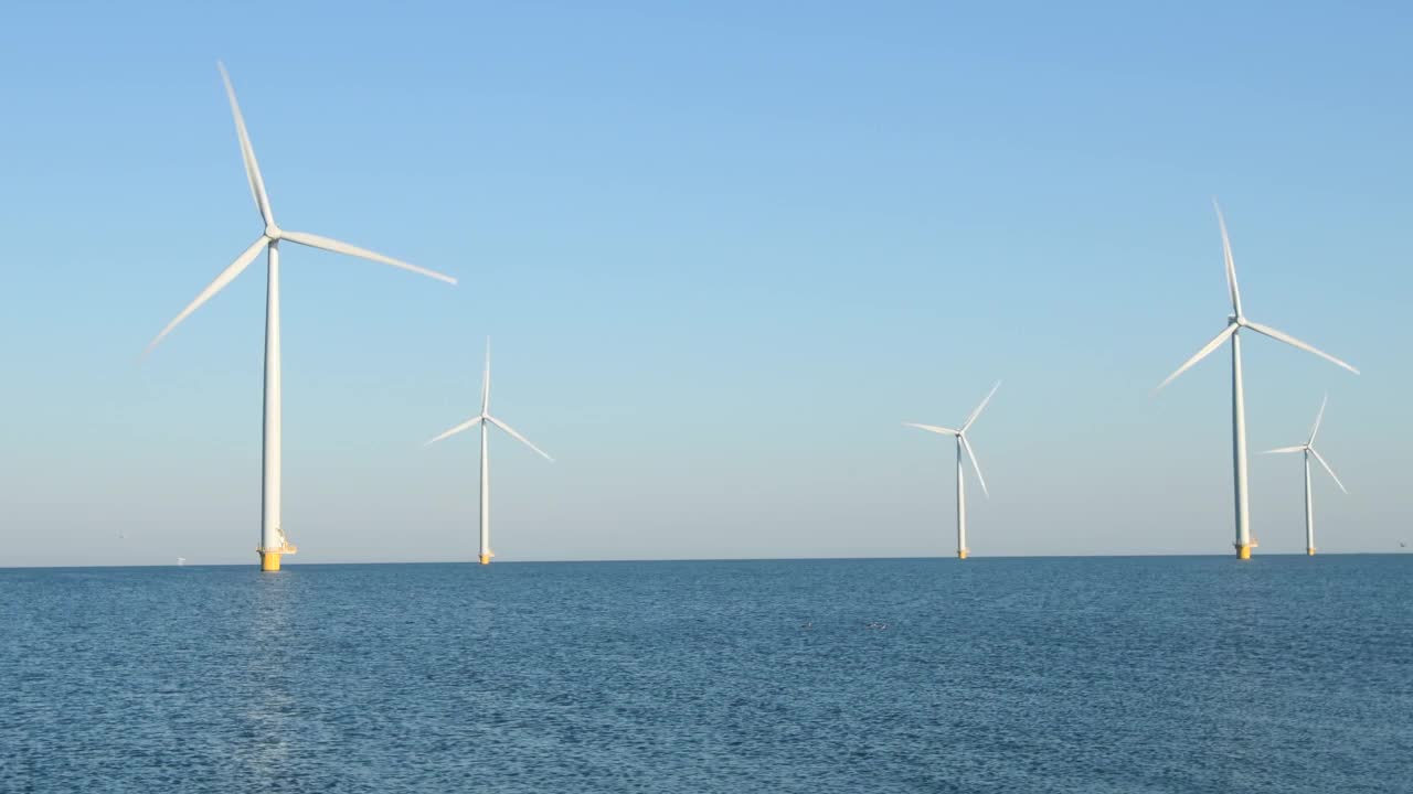 在海上风公园里，带有旋转叶片的风力涡轮机视频素材