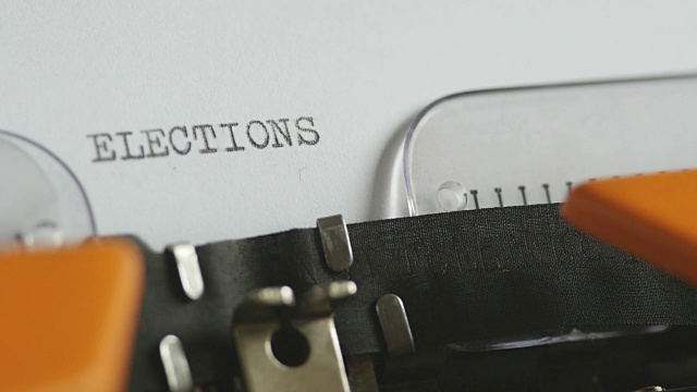 一个人用声音在一台旧打字机上写选举的特写镜头视频下载