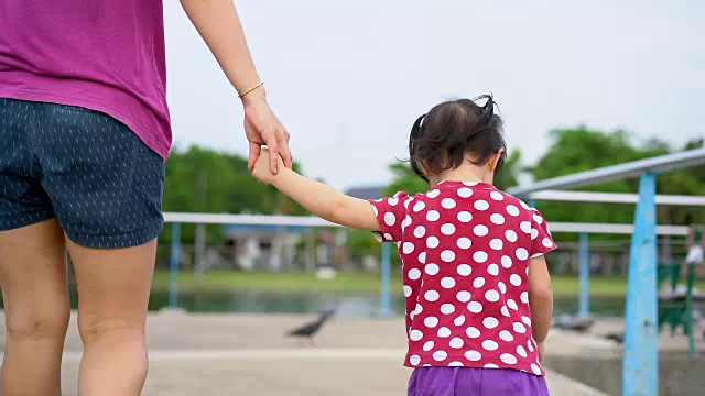 小女孩和妈妈在公园里散步。视频素材
