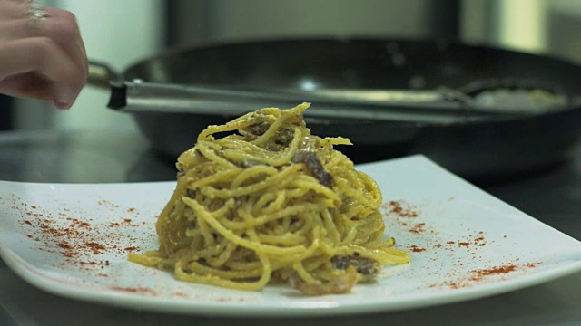 厨师在餐盘上的意大利面或意大利面中加入胡椒或香料视频素材