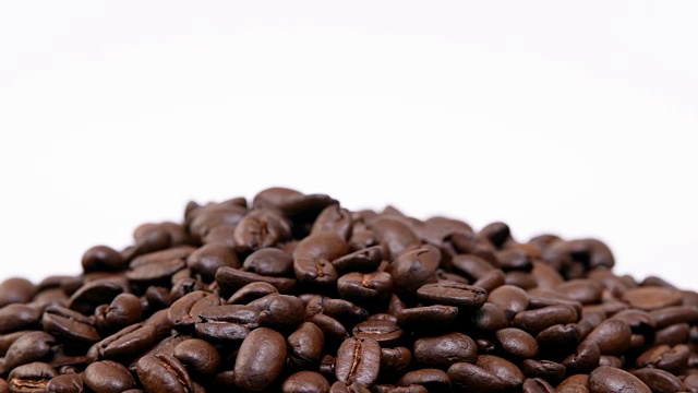 咖啡豆在白色背景上旋转。视频下载