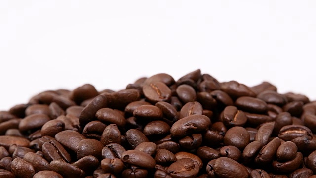 咖啡豆在白色背景上旋转。视频下载