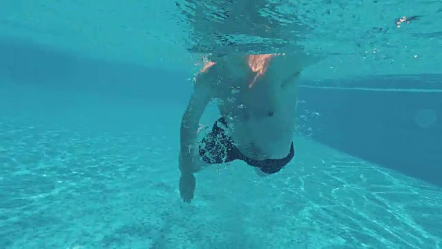 一个年轻人在游泳池的水下游泳视频下载