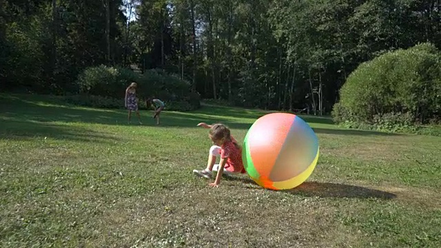 可爱的小女孩在玩一个五颜六色的大彩球视频素材