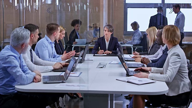 白人商务女性深色头发领导一个会议在玻璃会议室视频素材