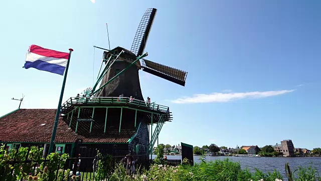 游客夫妇在荷兰阿姆斯特丹附近的扎桑斯山拍摄传统风车的照片视频下载