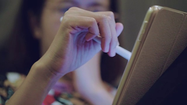 年轻的亚洲女性专业设计师在创意办公室使用图形平板电脑视频素材