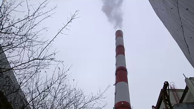 火电站冒烟的烟囱映衬着灰色的天空。冒烟的火电站烟囱。视频素材