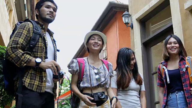 一群年轻人带着朋友们的背包一起走，快乐的朋友们正在拍照自拍，休闲度假的概念旅行视频素材